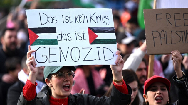 Une manifestante brandit une pancarte sur laquelle on peut lire "Ce n'est pas une guerre, c'est un génocide" lors d'une "Marche pour la Palestine" à Dortmund, dans l'ouest de l'Allemagne, le 28 octobre 2023.