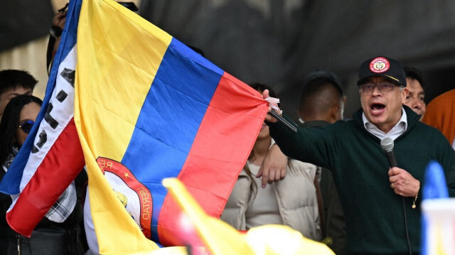 Le président colombien Gustavo Petro brandit le drapeau national lors d'un discours prononcé à l'occasion de la fête du travail à Bogota, le 1er mai 2024.