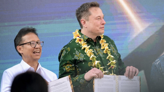 Le milliardaire de la technologie Elon Musk et le ministre indonésien de la Santé Budi Gunadi Sadikin posent pour des photos avec des documents encrés avant d'inaugurer l'unité satellite Starlink dans un centre de santé communautaire à Denpasar, sur l'île balnéaire indonésienne de Bali, le 19 mai 2024.
