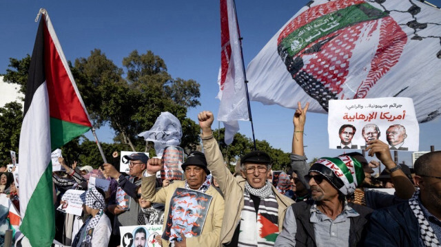 Des Marocains brandissent des drapeaux palestiniens et scandent des slogans lors d'une marche de solidarité avec la population de Gaza près du consulat américain à Casablanca, le 20 avril 2024.