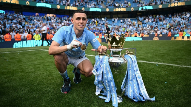 Le milieu de terrain de Manchester United Phil Foden pose avec le trophée de la Premier League, au stade Etihad à Manchester, le 19 mai 2024. 