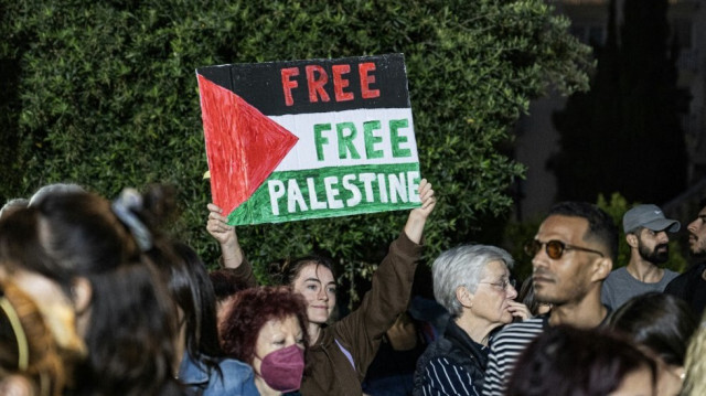 Un manifestant tient une pancarte sur laquelle on peut lire "Free free Palestine" alors que des étudiants et des manifestants pro-palestiniens se rassemblent lors d'une manifestation de soutien au peuple palestinien devant le bâtiment central de l'Université d'Athènes, à Athènes, le 13 mai 2024.