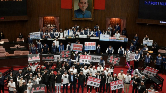 Les législateurs du Kuomintang (KMT), principal parti d'opposition à Taiwan, se rassemblent près du siège du président du Parlement tandis que les législateurs du Parti démocrate progressiste (DPP), au pouvoir, affichent des pancartes sur lesquelles on peut lire "anti-boîte noire et retour à un nouveau procès". Ils protestent avant de voter le projet de loi de réforme du Parlement à Taipei, le 21 mai 2024.