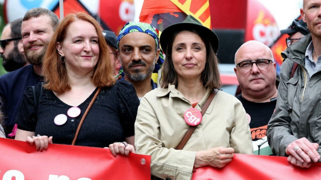 Sophie Binet (C) de la CGT et Murielle Guilbert (G) de Solidaires défilent avec d'autres syndicalistes derrière une banderole lors de la manifestation annuelle marquant la Journée internationale du travail, également connue sous le nom de Journée des travailleurs ou de Premier Mai, à Paris, le 1er mai 2024.