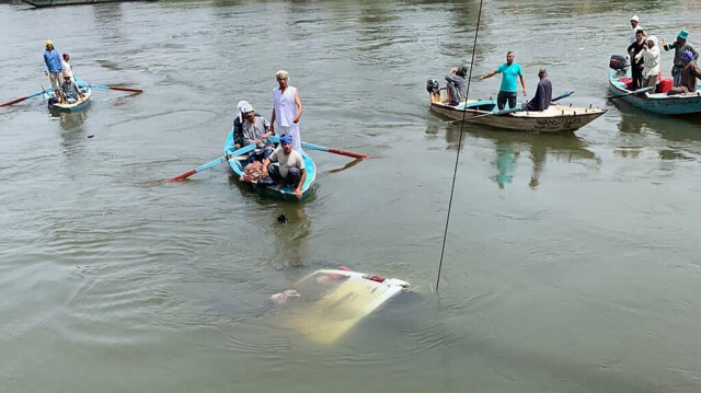 Des sauveteurs s'efforcent de retirer un minibus coulé d'un canal du Nil près du village d'Abu Ghaleb dans le gouvernorat égyptien de Giza, le 21 mai 2024. 