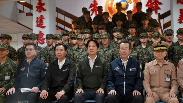 Le président taïwanais Lai Ching-te (au centre) pose pour des photos avec des membres du corps de la marine lors d'une visite d'inspection des troupes militaires à Taoyuan le 23 mai 2024.