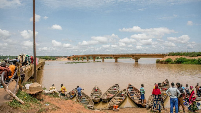 Des passagers se rassemblent près de pirogues motorisées informelles prêtes à faire traverser le fleuve Niger qui divise le Bénin et le Niger dans la ville de Malanville, le 18 septembre 2023.