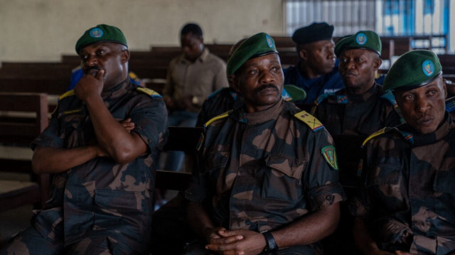 Des soldats de l'armée congolaise accusés de désertion et de lâcheté lors des combats contre les rebelles du M23 réagissent alors qu'ils sont assis sur le banc des accusés lors d'un procès à la cour militaire du Nord-Kivu à Goma, le 03 mai 2024.