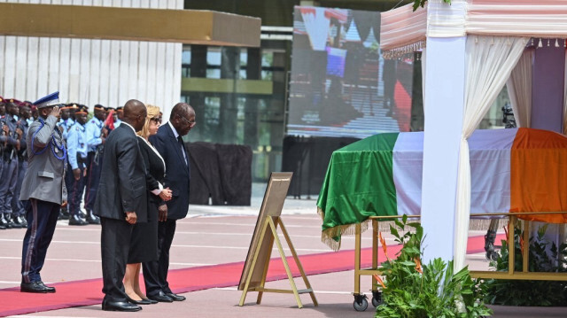 Le président ivoirien Alassane Ouattara (CR) et son épouse Dominique Ouattara (CL) rendent hommage au défunt président ivoirien Henri Konan Bedie lors de l'hommage de la nation dans le cadre de ses funérailles au palais présidentiel à Abidjan, le 24 mai 2024.