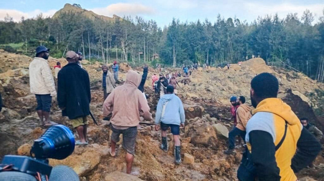 Des personnes se rassemblent sur le site d'un glissement de terrain à Maip Mulitaka, dans la province d'Enga, en Papouasie-Nouvelle-Guinée, le 24 mai 2024.