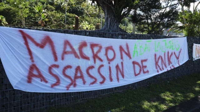 Une banderole installée le long d'une route suite à la visite du président français Emmanuel Macron à Nouméa, en Nouvelle-Calédonie dans le Pacifique, le 24 mai 2024.