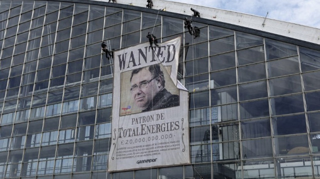 Une banderole portant le portrait du PDG de TotalEnergies, Patrick Pouyanné, affichéepar des militants écologistes avant l'assemblée générale des actionnaires de la multinationale française TotalEnergies, le 24 mai 2024. 
