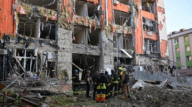 Des pompiers inspectent un immeuble de bureaux lourdement endommagé à la suite d'une attaque aérienne russe à Kharkiv, le 25 mai 2024.