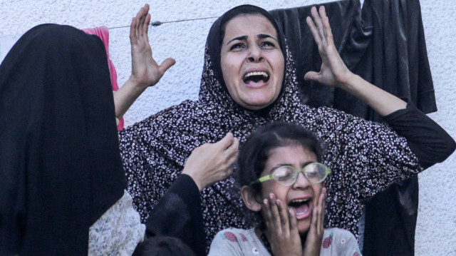 Des Palestiniens réagissant après une frappe israélienne sur un bâtiment à Nuseirat, le 25 mai 2024, alors que les combats se poursuivent entre Israël et le Hamas dans la bande de Gaza.