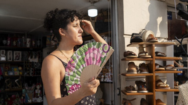 Une femme se rafraîchit à l'aide d'un ventilateur à l'extérieur d'un magasin de chaussures à Veracruz, dans l'État de Veracruz, au Mexique, le 24 mai 2024.