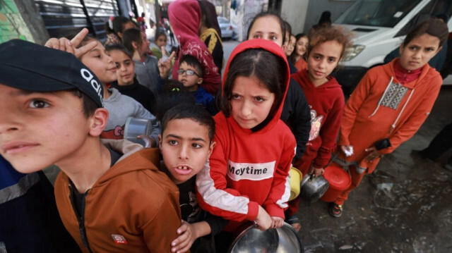 Des enfants palestiniens recevant des rations de nourriture cuisinée dans le cadre d'une initiative de jeunes volontaires à Rafah, dans le sud de la bande de Gaza, le 5 mars 2024, alors que la faim est généralisée dans le territoire palestinien assiégé par le conflit entre Israël et le groupe militant palestinien Hamas.