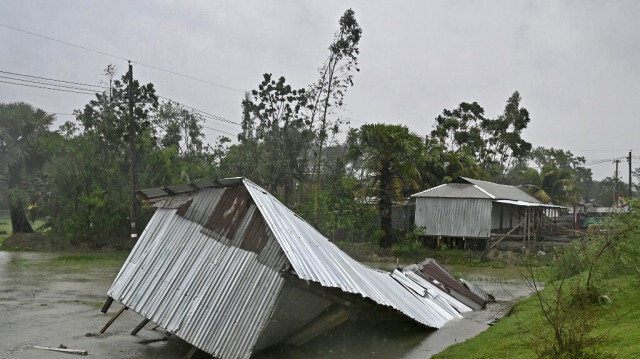 Une maison endommagée est vue pendant la pluie à Patuakhali le 27 mai 2024, après l'arrivée du cyclone Remal au Bangladesh.