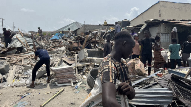 Des habitants portent leurs affaires après la démolition d'une partie du quartier de Jakande à Lagos, le 14 mars 2024.