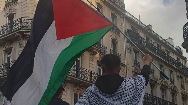 Un manifestant brandit un drapeau palestinien en signe de protestation contre les frappes israéliennes sur Rafah et demande un cessez-le-feu immédiat.