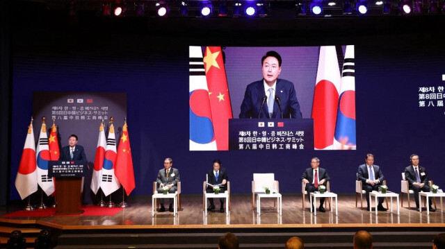 Le président sud-coréen Yoon Suk Yeol s'exprime alors que le premier ministre japonais Fumio Kishida (3e, à gauche) et le premier ministre chinois Li Qiang (à droite) écoutent lors d'un sommet commercial à la Chambre de commerce et d'industrie de Corée à Séoul, le 27 mai 2024.