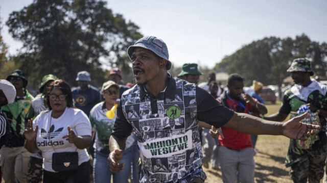 Des partisans du nouveau parti politique uMkhonto weSizwe (MK) dansent et chantent alors qu'ils se rendent au dernier rassemblement du MK à eMalahleni, le 26 mai 2024, avant les élections sud-africaines prévues pour le 29 mai 2024. 