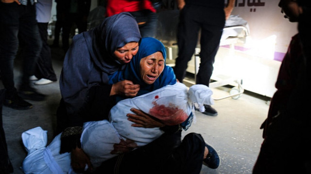 Une femme palestinienne tient le corps enveloppé d'un enfant tué lors d'un bombardement israélien dans la région de Tel al-Sultan à Rafah, dans le sud de la bande de Gaza, le 26 mai 2024.