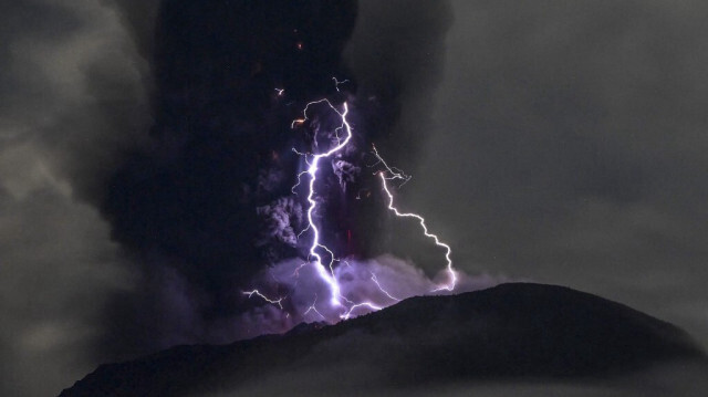 Le Mont Ibu crachant des cendres volcaniques alors que la foudre frappe, vu depuis le poste de surveillance à Halmahera Ouest, Maluku Nord en Indonésie.