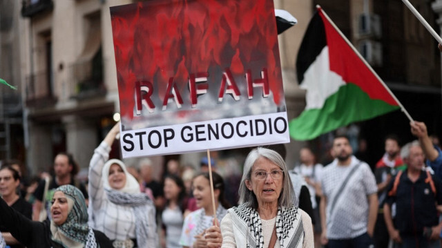 Un manifestant brandit une pancarte sur laquelle on peut lire "Rafah, stop au génocide" lors d'une manifestation pro-palestinienne, devant le ministère des Affaires étrangères à Madrid, le 27 mai 2024. 