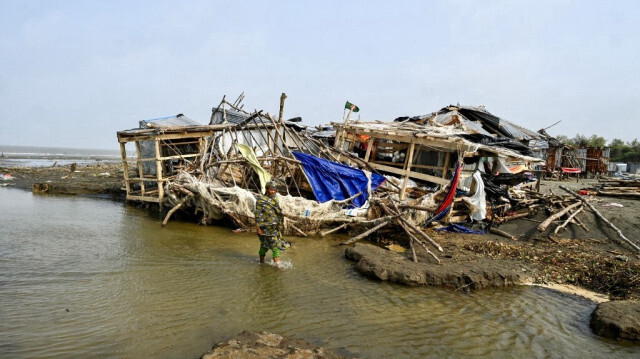 Une femme passe devant un magasin endommagé après l'arrivée du cyclone Remal à Patuakhali, le 29 mai 2024.