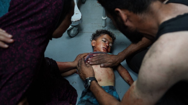 La mère de l'enfant palestinien Khaled Abu Samaha lui tient l'épaule alors qu'un homme tente de lui sauver la vie à l'hôpital Al-Aqsa Martyrs dans le centre de la bande de Gaza après qu'il ait été gravement blessé lors d'un bombardement israélien sur une maison dans la ville de Nuseirat le 27 mai 2024.