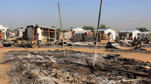 Des habitants passent devant des maisons brûlées à la suite de multiples attaques menées par les terroristes de Boko Haram à Dalori et dans d'autres villages voisins à l'extérieur de Maiduguri, capitale de l'État de Borno, dans le nord-est du Nigéria, le 1er novembre 2018. 