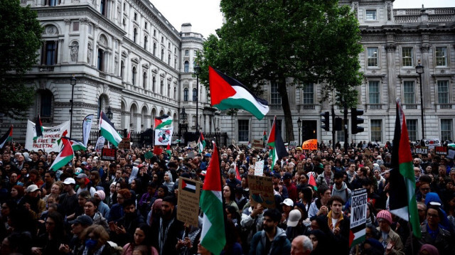 Des manifestants brandissent des drapeaux palestiniens et des pancartes lors d'un rassemblement appelant à un cessez-le-feu à Gaza, suite à l'attaque d'Israël à Rafah, devant Downing Street, au centre de Londres, le 28 mai 2024.