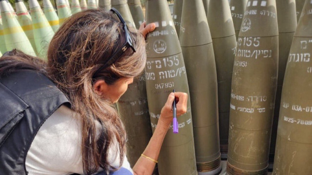 L'ancienne candidate républicaine à l'élection présidentielle américaine Nikki Haley écrit "Achevez-les" sur un obus israélien, dans le nord d'Israël, près de la frontière libanaise, lors d'une visite le 28 mai 2024.