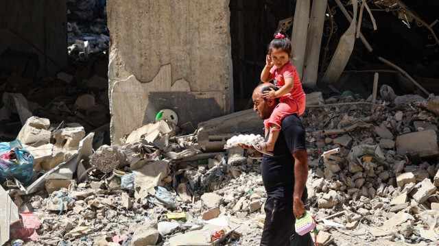 Une famille palestinienne au milieu de logements détruits par l'armée d'occupation israélienne, à Khan Younes, dans le sud de la bande de Gaza, le 24 mai 2024.