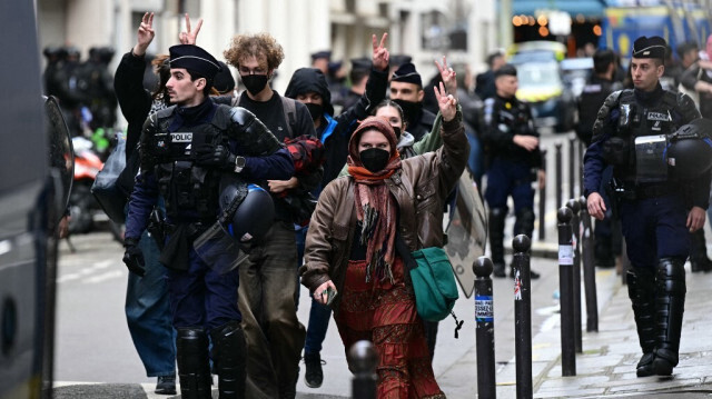 Des étudiants manifestent avec le signe de la victoire pendant qu'ils sont escortés par des gendarmes français lors de l'évacuation d'un sit-in pro-Gaza dans le hall d'entrée de l'Institut d'études politiques (Sciences Po Paris), à Paris, le 3 mai 2024.