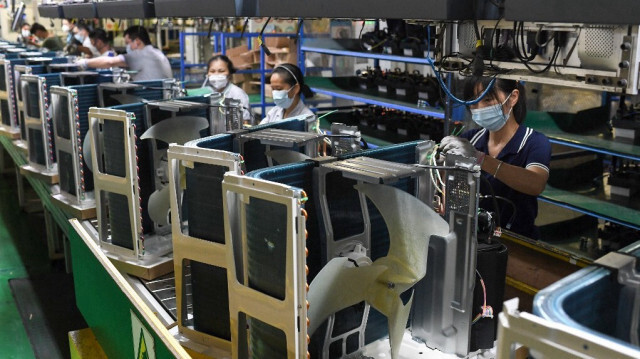 Employés travaillant sur une chaîne de production de climatiseurs dans une usine de Wuhan, dans la province centrale du Hubei en Chine.