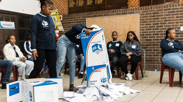 Des fonctionnaires de la Commission électorale d'Afrique du Sud (IEC) vident une urne pendant le processus de comptage des votes au bureau de vote de l'école primaire Addington lors des élections générales d'Afrique du Sud à Durban, le 29 mai 2024. 