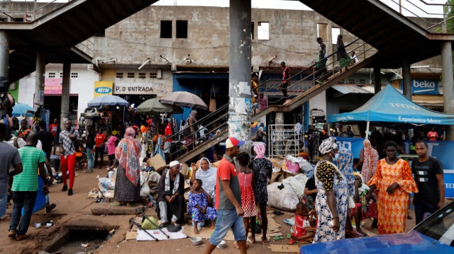 Des personnes marchent et font des achats dans les rues de Bissau, le 28 juillet 2022, dans le cadre d'une visite officielle du Président français.