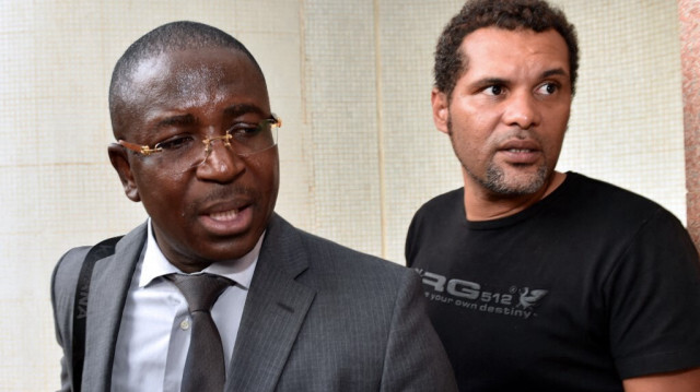 Guy Herve Kam, avocat du mouvement ''Balai Citoyen'' se tient à côté du musicien burkinabé et porte-parole du ''Balai Citoyen'' Serge Martin Bambara Smockey (R), lors des négociations sur le gouvernement de transition après l'éviction du dirigeant de longue date du pays au Burkina Faso, le 12 novembre 2014 à Ouagadougou.