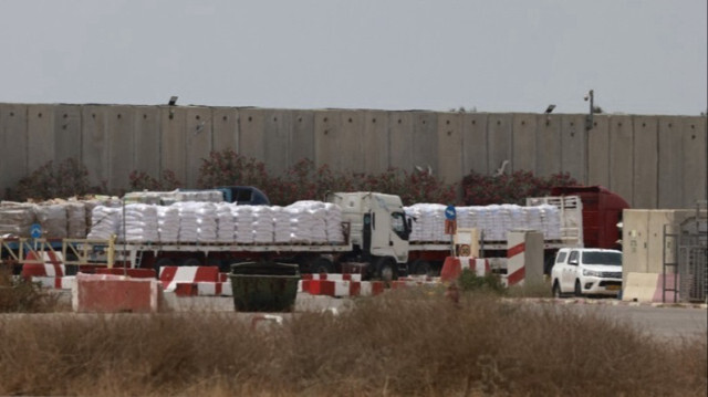 Des camions transportant de l'aide humanitaire attendent du côté israélien du poste-frontière de Kerem Shalom avec la bande de Gaza, dans le sud d'Israël.