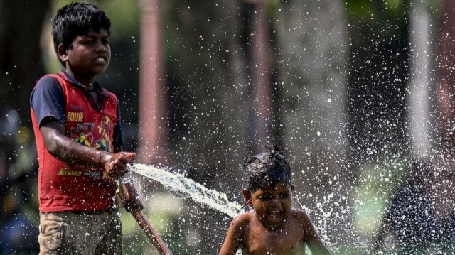 Des enfants jouent avec de l'eau pendant une chaude journée d'été au milieu d'une vague de chaleur sévère à New Delhi le 31 mai 2024.