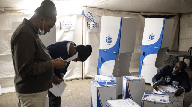 Un fonctionnaire de la Commission électorale d'Afrique du Sud (IEC) scotche une urne devant des observateurs électoraux au bureau de vote Vasco à Alexandra, près de Johannesburg, le 29 mai 2024, lors des élections générales d'Afrique du Sud.  