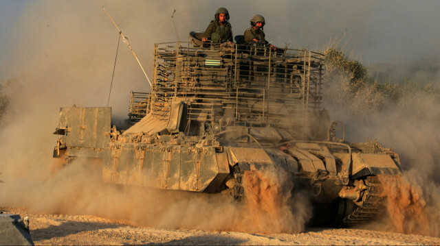 Des soldats israéliens sont assis sur un véhicule blindé de transport de troupes pénétrant en territoire palestinien dans le nord de la bande de Gaza, à la frontière près du kibboutz Zikim.