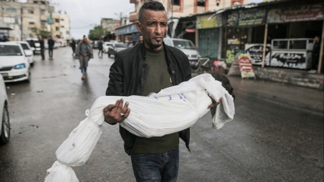 Un Palestinien porte le corps enveloppé d'un enfant tué lors d'une attaque israélienne à Rafah dans la Bande de Gaza, le 06 mai 2024.