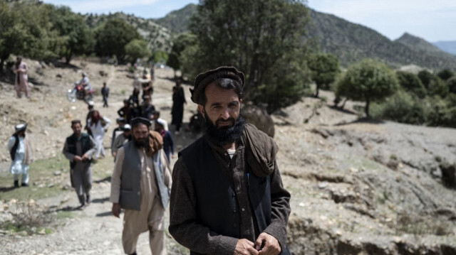Badshah Khan, instituteur et chef de la tribu afghane des Balkhel, marchant avec des locaux dans la région de Balkhel du district de Janikhel dans la province de Paktia le 22 avril 2024.