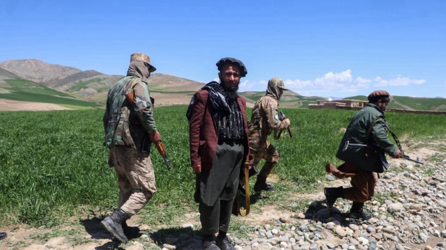 Le personnel de sécurité armé des talibans marche le long d'un champ de blé dans le district d'Argo, dans la province de Badakhshan, le 6 mai 2024.