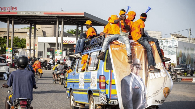 Des partisans du parti d'opposition Alliance nationale pour le changement (ANC) applaudissent depuis un minibus alors qu'ils font campagne dans les rues de Lomé, le 27 avril 2024. 