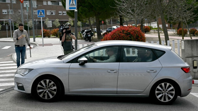 Des journalistes prennent des photos alors que la Garde civile espagnole (Guardia Civil) et des officiers d'Europol quittent une voiture après une perquisition au siège de la Fédération royale espagnole de football (RFEF) à Las Rozas de Madrid, le 20 mars 2024. 