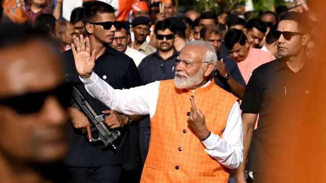 Le Premier ministre indien Narendra Modi, leader du parti au pouvoir Bharatiya Janata Party (BJP), fait un geste en direction de la foule alors qu’il part après avoir voté dans un bureau de vote à Ranip, Ahmedabad, le 7 mai 2024. 