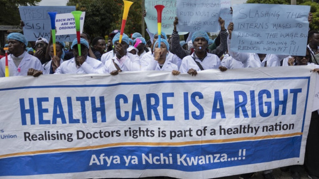 Des médecins kenyans manifestent devant le siège du ministère de la santé avec des pancartes pour réclamer de meilleurs salaires et conditions de travail dans la capitale, Nairobi, le 9 avril 2024. 